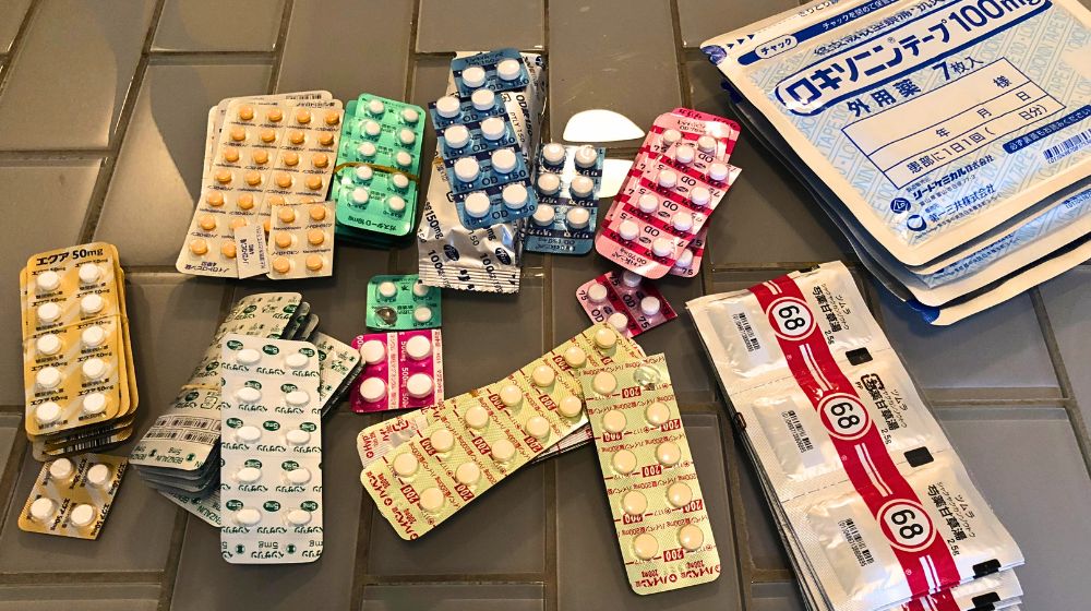 テーブルの上に広げられた複数の錠剤シートと薬袋